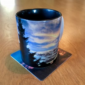 Evergreen silhouette against painted clouds - two-tone mug