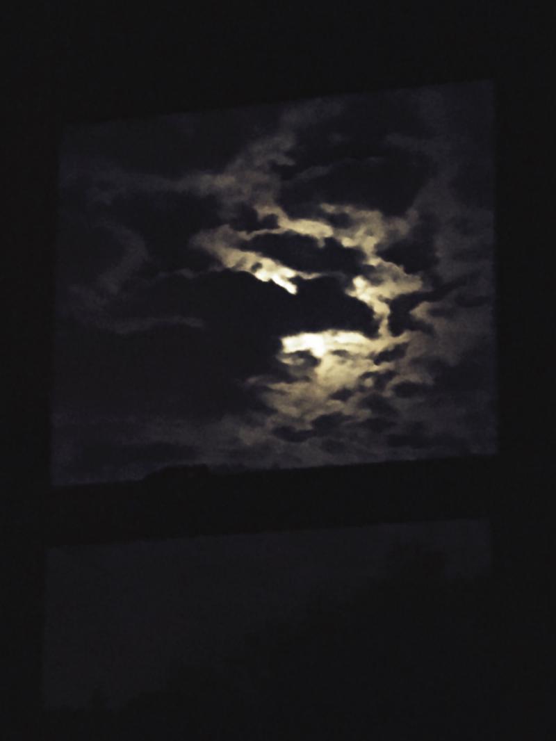 Full mooon waning behind the clouds