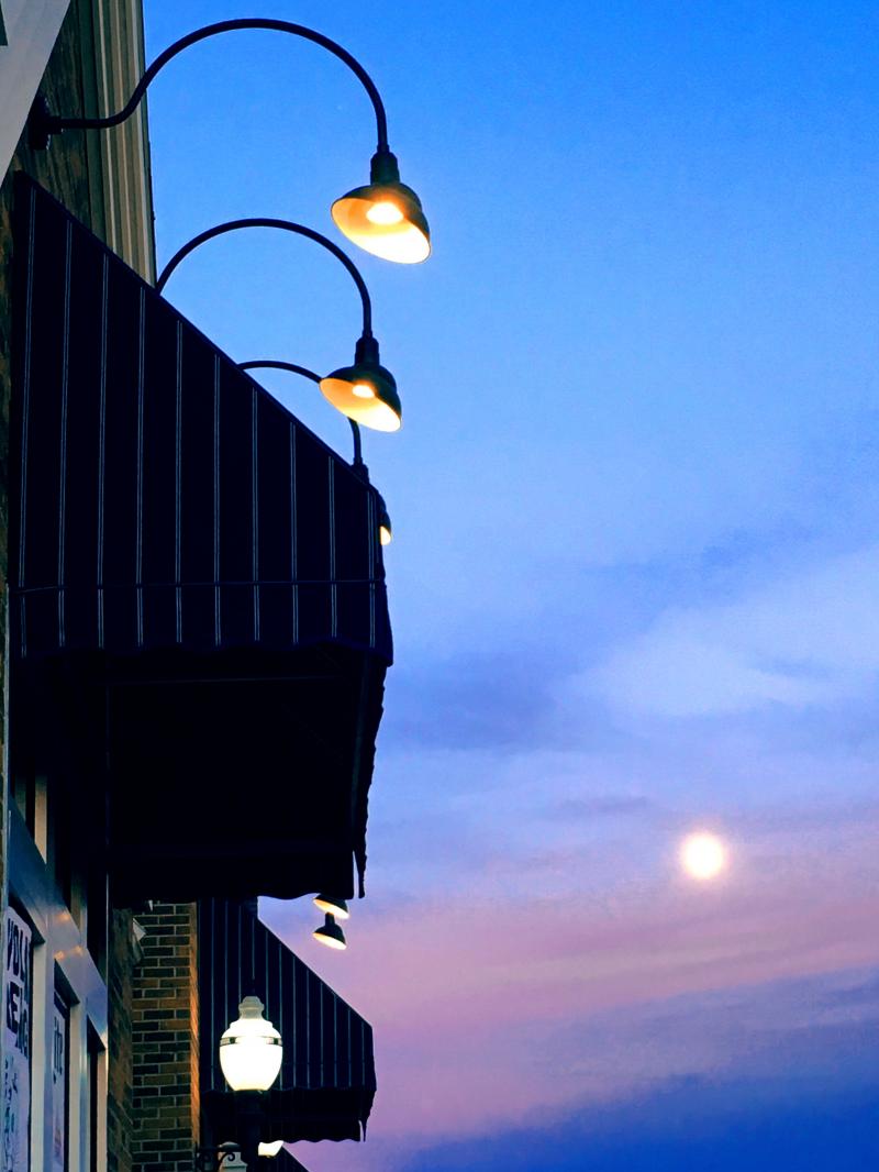 A rising moon on a blue and purple sky
