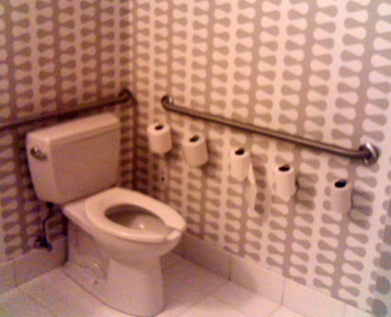 Restroom with several rolls of toilent paper