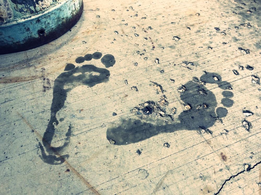 Wet foot prints by the milk can
