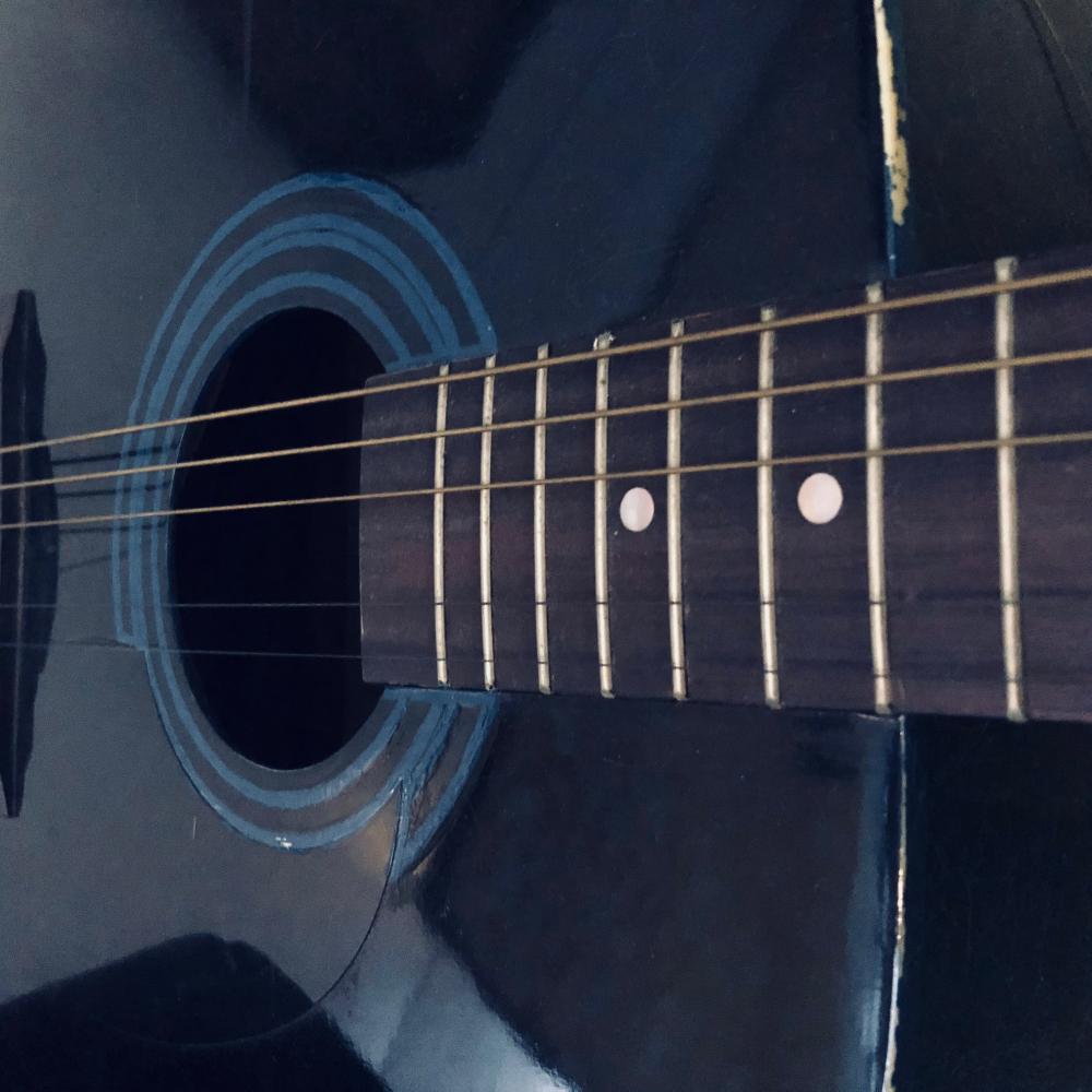 Black acoustic guitar up close