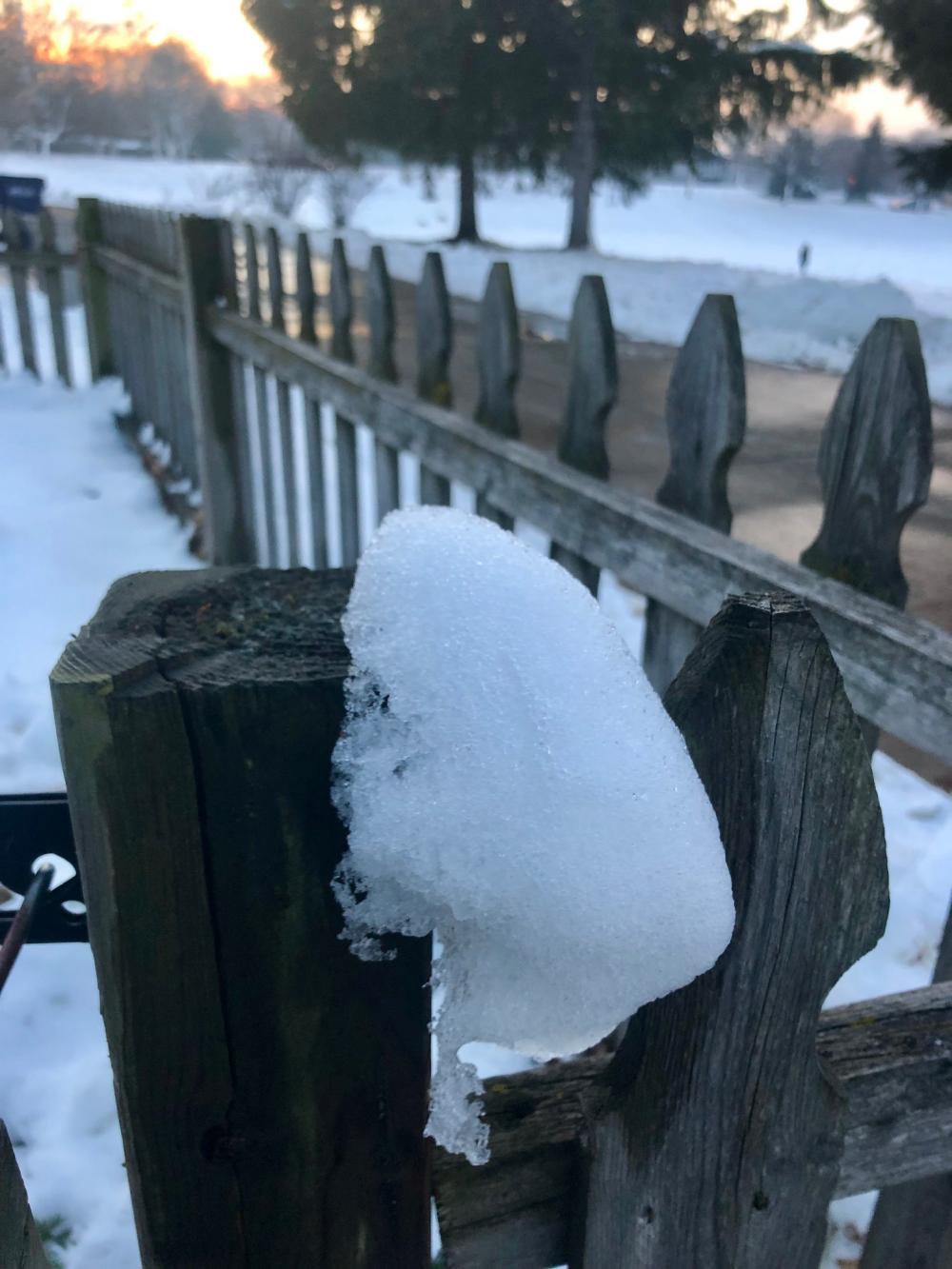 Snow still on the wooden fence