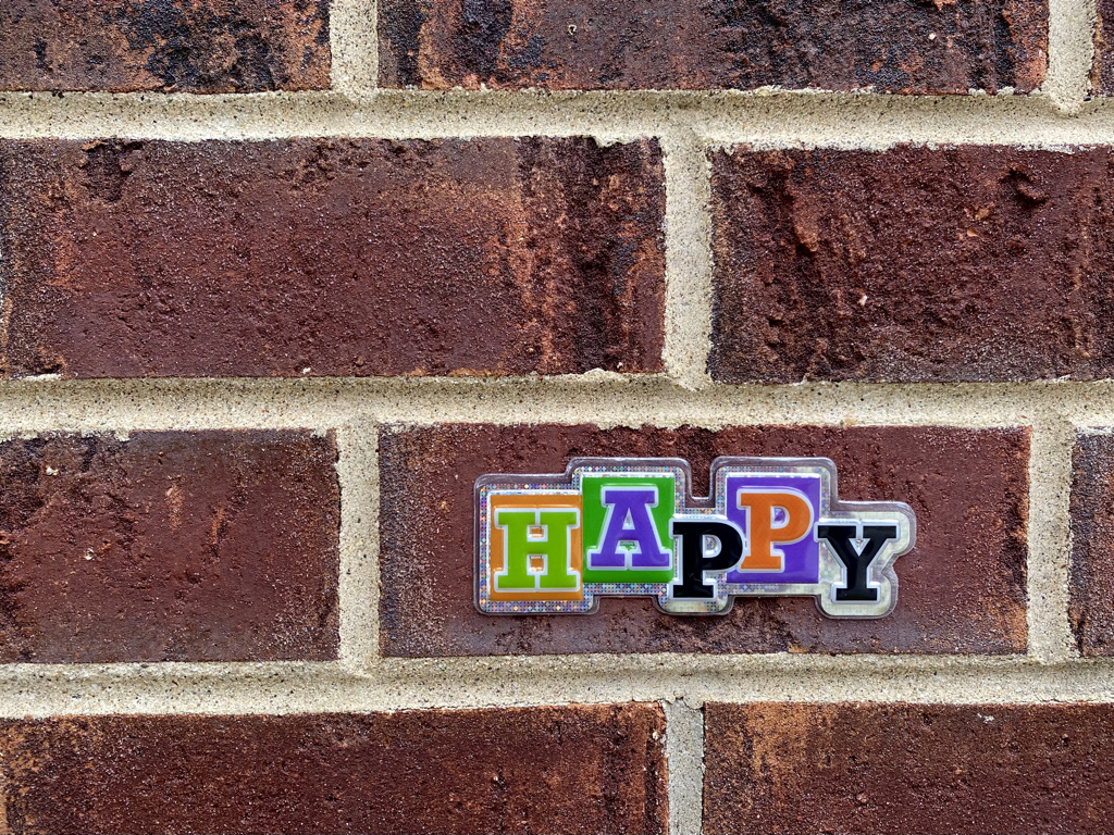 Happy sticker on a brick building